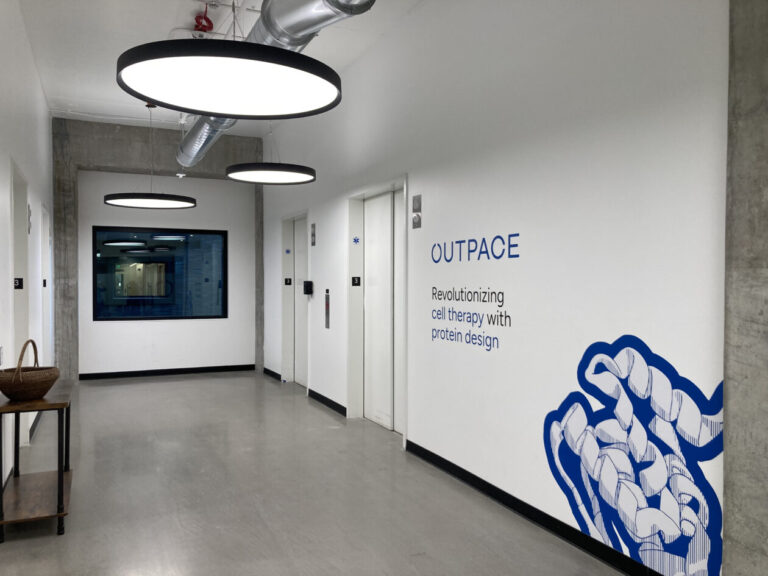 hallway showing entry of Outpace with company logo on wall