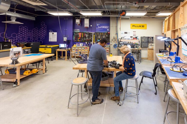 Hardware Incubator with two people working in area with tool library
