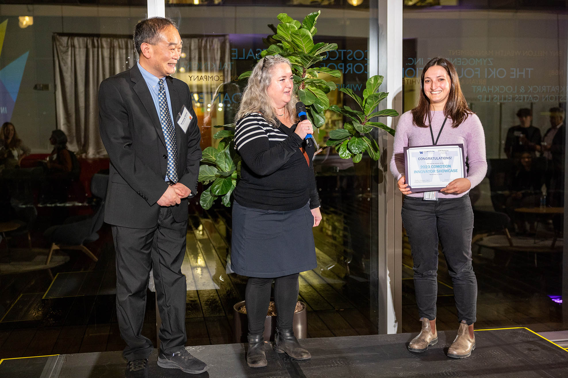 Ricky Wang, Jennifer McCullar and Felicia Watson as Felicia receives an award on a stage