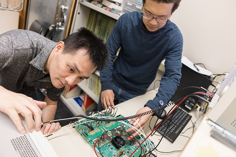 UW ECE graduate students Yi-Hsiang Huang (left) and Xichen Li (right) working in the lab of Professor Chris Rudell