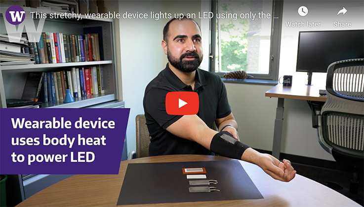 scientist demonstrating wearable device that uses body heat to power LED