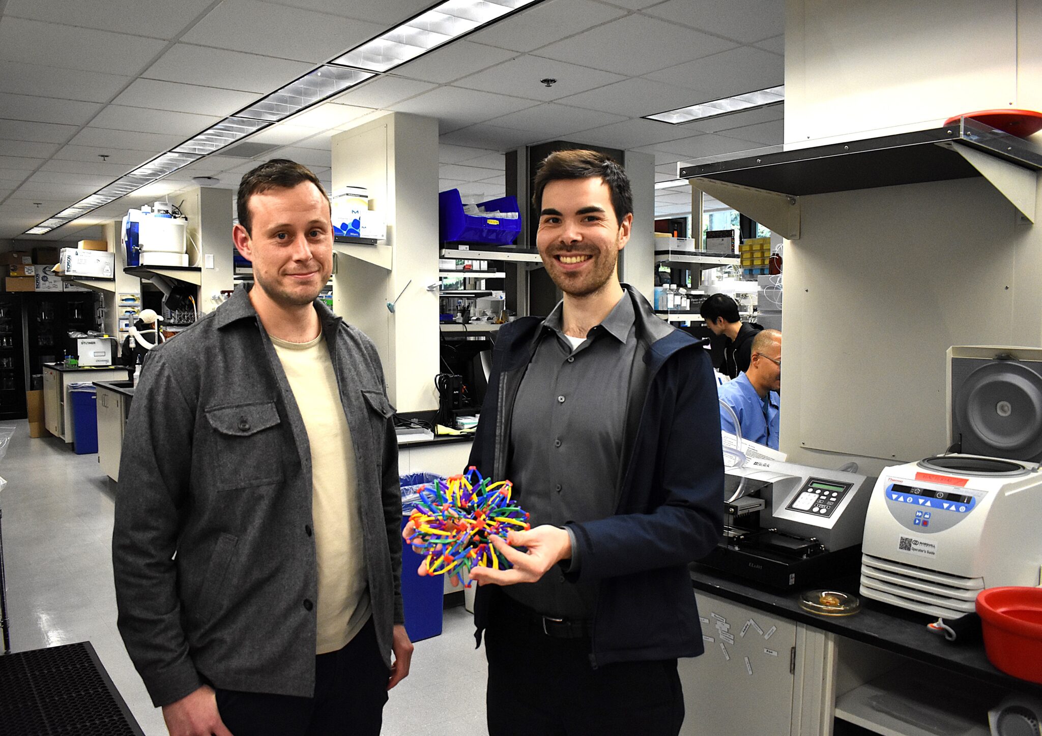 Archon Biosciences founders holding expandable toy that he uses to demonstrate how the company’s computationally designed Antibody Cages work.
