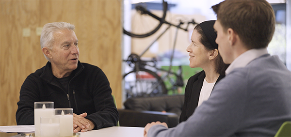 Three people are engaged in a consultation.