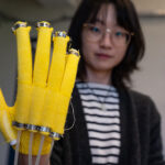 knit glove preoject in UW robotics lab with researcher looking on.